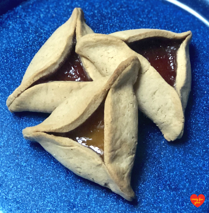3 baked Hamantashen on a blue plate. 