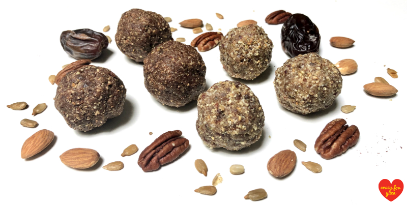 CrazyForYuca.com - 6 Paleo No-Bake Date Nut Balls with scattered nuts and dates, white background
