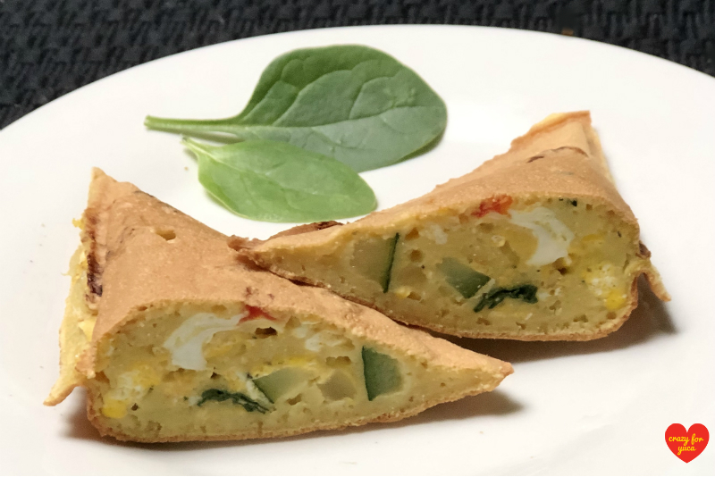 Grain-Free Pancake Pocket cut open showing vegetable egg filling on white plate. CrazyForYuca.com