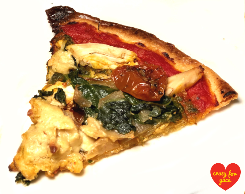 One slice Paleo Yuca Pizza with Vegan Cheese sautéed vegetables, and chicken. White background.