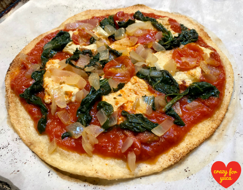 Whole Paleo Yuca Pizza with Vegan Cheese personal pie on parchment.